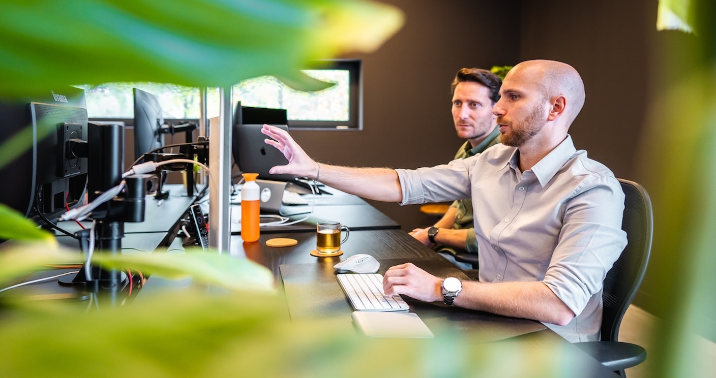 Ruud laat iets aan Toine zien op zijn computerscherm.